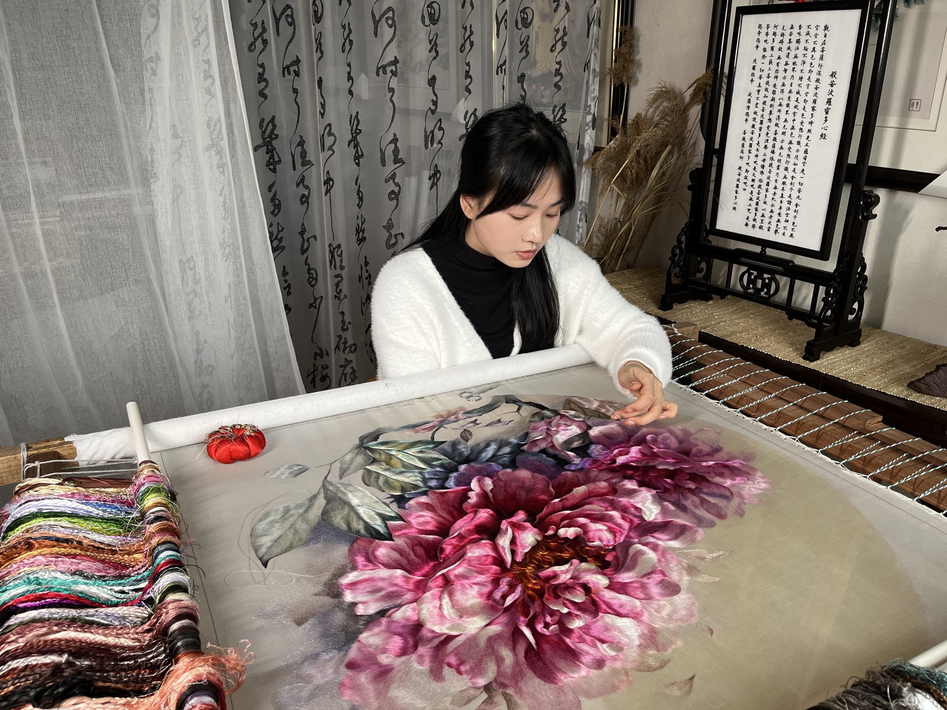 杨雪在绷架上绣制大型牡丹作品