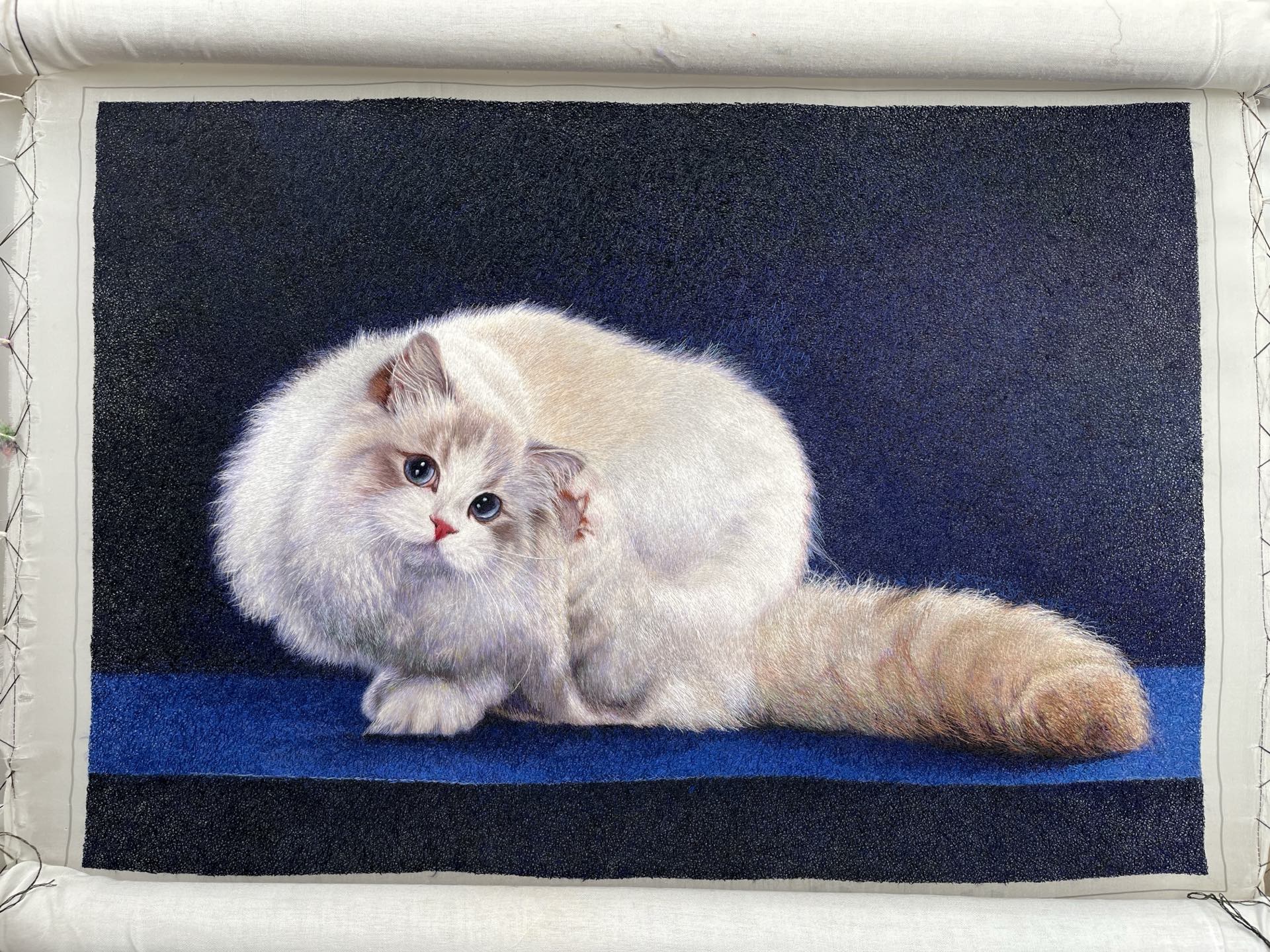 绷架上的白色长毛猫苏绣作品