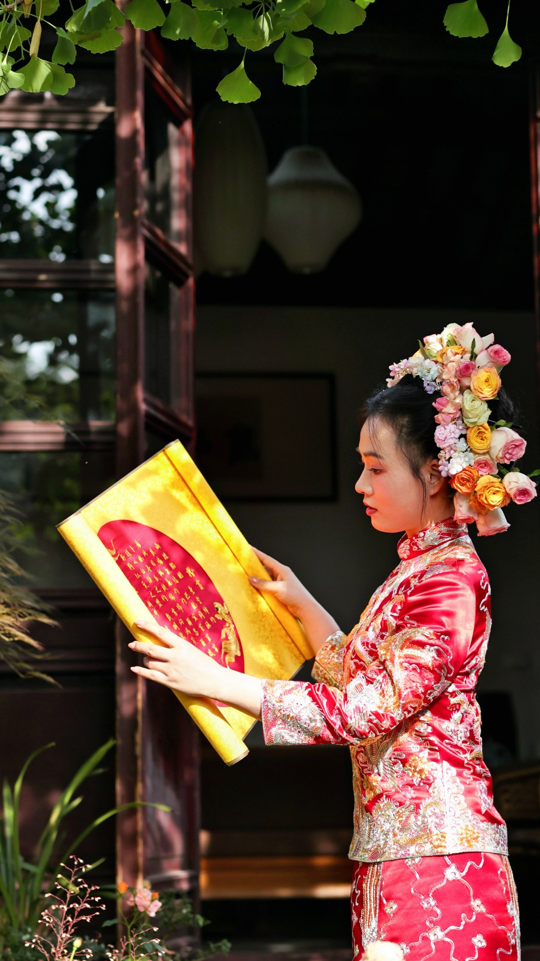 身着中式礼服的新娘手持刺绣婚书